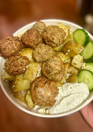 A picture of Greek turkey meatballs over lemon dill potatoes.