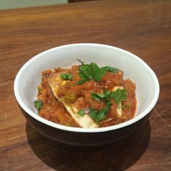 A picture of Papad stuffed with paneer in tomato and onion gravy.