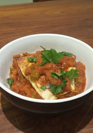 A picture of Papad stuffed with paneer in tomato and onion gravy.