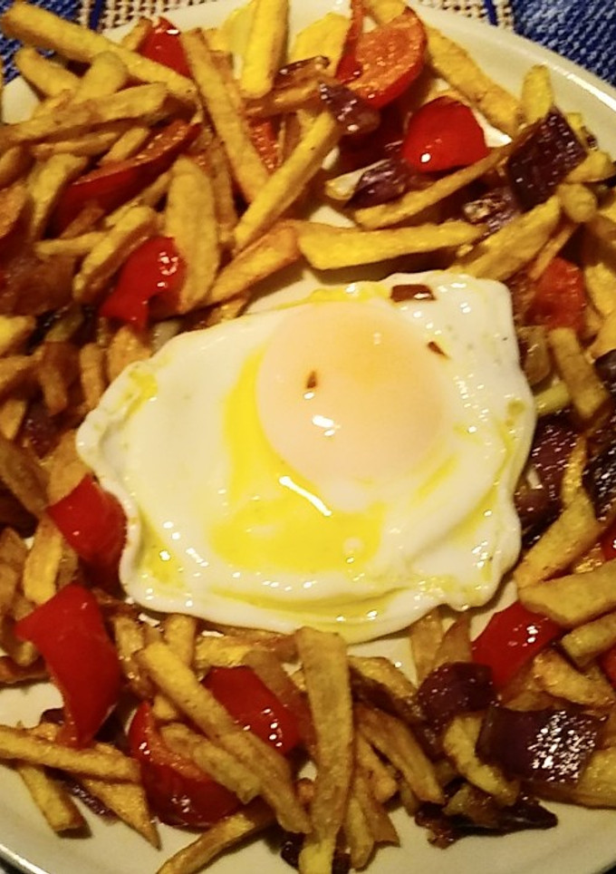 Una foto de Huevos rotos con pimiento y cebolla