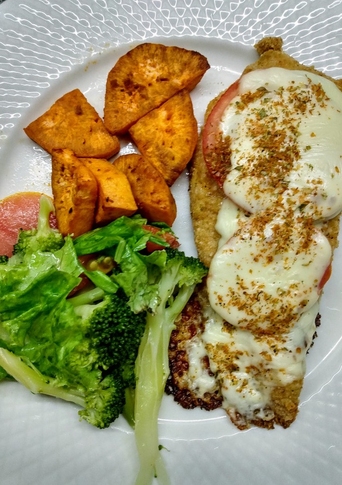 Una foto de Milanesa de pollo a la napolitana con ensalada y boniato