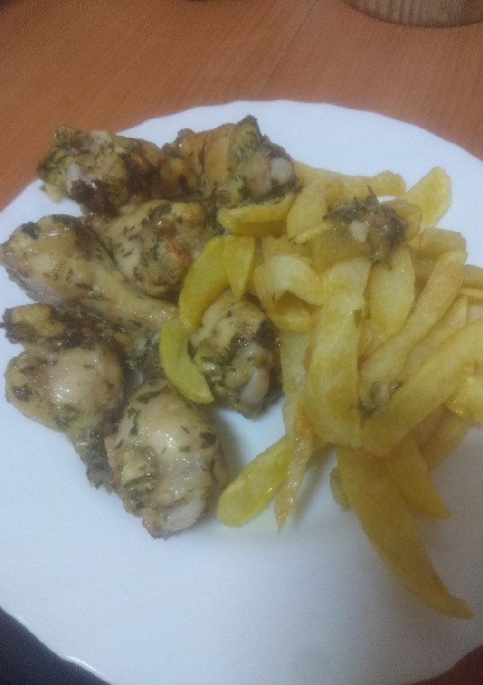 Una foto de Muslitos de pollo al ajillo al horno con papas fritas