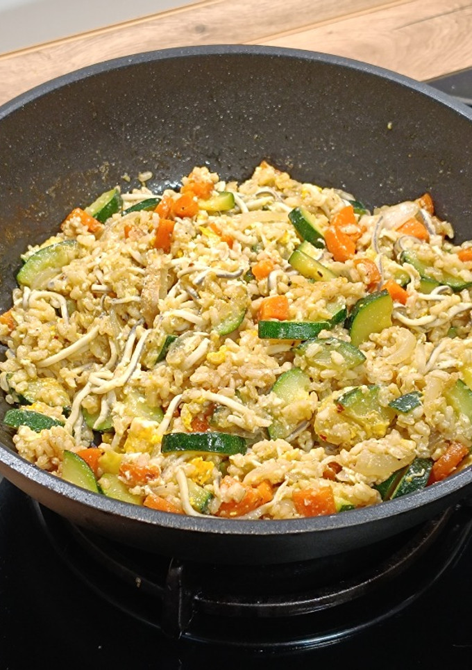 Una foto de Wok de arroz integral salteado con gulas y calabacín