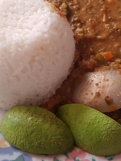 A picture of Rice served with green grams and Ovacado.