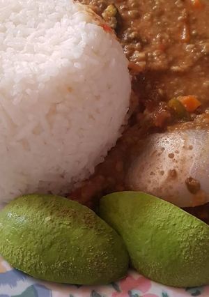 A picture of Rice served with green grams and Ovacado.