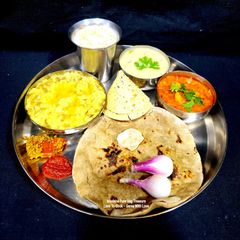 A picture of Gujarati Thali - Bajara Rotlo - Lasooni Aloo Sabzi - Khichdi - Kadhi (Dinner).