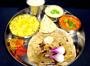 A picture of Gujarati Thali - Bajara Rotlo - Lasooni Aloo Sabzi - Khichdi - Kadhi (Dinner).