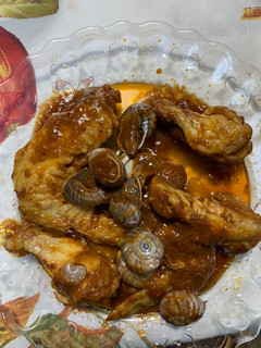 Una foto de Alas de pollo con caracoles y tomate