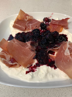 Una foto de Burrata con arándanos confitados y jamón