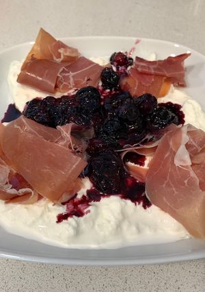 Una foto de Burrata con arándanos confitados y jamón