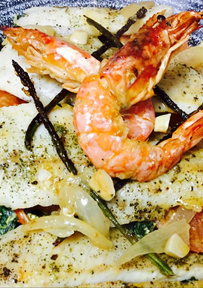 Una foto de Merluza al horno con rodajas de tomate y revuelto de espinacas