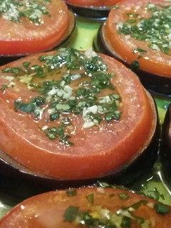 Una foto de Medallones de berenjena y tomate con albahaca al ajo