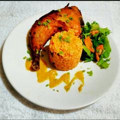 A picture of Jollof Rice with Oven Grilled Chicken and Chinese Salad.