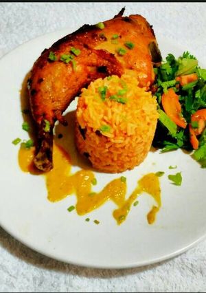 A picture of Jollof Rice with Oven Grilled Chicken and Chinese Salad.