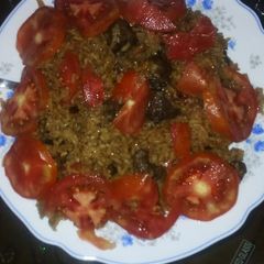 Beef pilau garnished with tomatoes A picture of Beef pilau garnished with tomatoes.