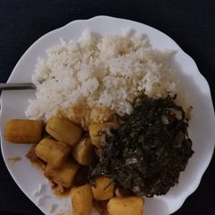 A picture of Rice, beef stew with bananas and greens.