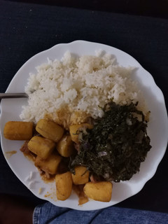 A picture of Rice, beef stew with bananas and greens.