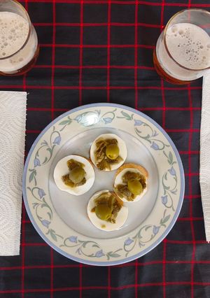Una foto de Almejas sentadas en tostas de pan en cojín de láminas de queso fresco