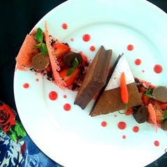 A picture of Ragi tart with Bitter Chocolate chilli Mousse, Ragi chocolate soil Strawberry compote and tuile.