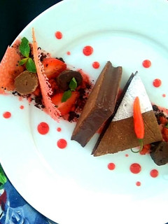 A picture of Ragi tart with Bitter Chocolate chilli Mousse, Ragi chocolate soil Strawberry compote and tuile.