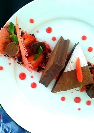 A picture of Ragi tart with Bitter Chocolate chilli Mousse, Ragi chocolate soil Strawberry compote and tuile.