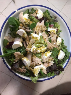 Una foto de Ensalada de pollo, garbanzos, queso y lechugas variadas a la salsa de miel y pesto