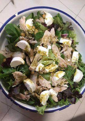 Una foto de Ensalada de pollo, garbanzos, queso y lechugas variadas a la salsa de miel y pesto