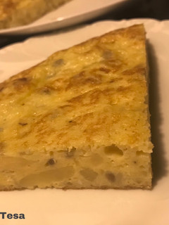 Una foto de Tortilla de patatas del cocido y cebollita roja