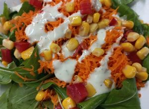 Una foto de Ensalada de Rúcula, Zanahoria, Tomate y Choclo  con Salsa Ranch La Spezia
