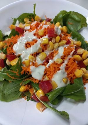 Una foto de Ensalada de Rúcula, Zanahoria, Tomate y Choclo con Salsa Ranch La Spezia
