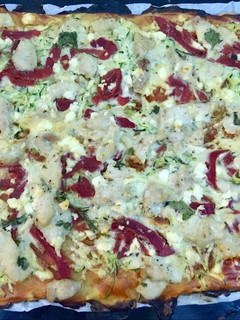 Una foto de Coca de hojaldre con pollo picante, piquillos y queso fresco
