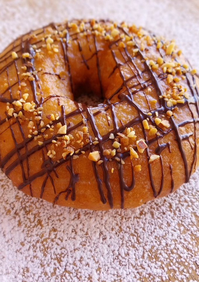 Una foto de Donut con cobertura de chocolate y crocanti