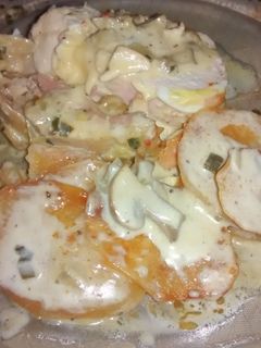 Una foto de Arrollado de pollo con papas españolas y salsa de hongos