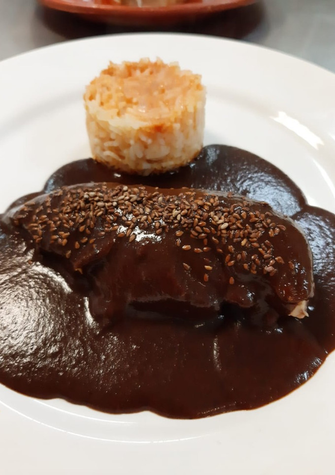 Una foto de Mole poblano con arroz rojo (Puebla)