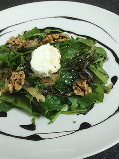Una foto de Ensalada de espinacas, queso de cabra, nueces, cebolla caramelizada