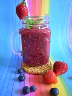 Una foto de Smoothie de fresas, arándanos, naranja y hierbabuena