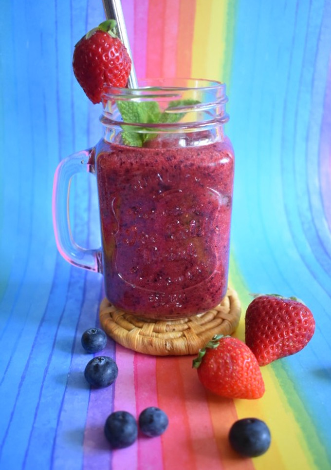 Una foto de Smoothie de fresas, arándanos, naranja y hierbabuena