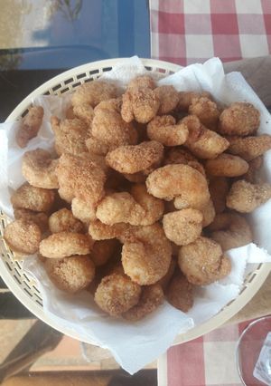 Una foto de Camarones rebozados y fritos con bastoncitos de queso