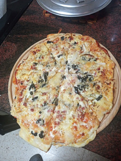 Una foto de Pizza de aceitunas negras, cebolla y jamón serrano
