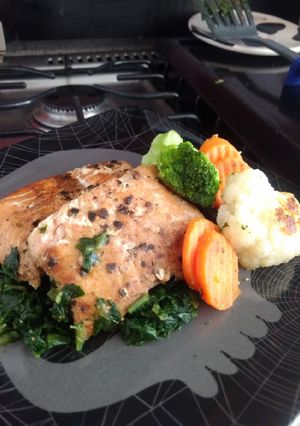 Una foto de Salmón asado en cama de espinacas y verduras asadas