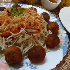 A picture of Cheese balls with noodles in tomato sauce.