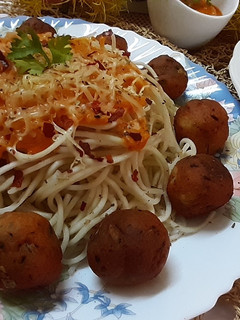 A picture of Cheese balls with noodles in tomato sauce.