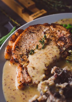 A picture of Pork Chops With A Creamy Cider & Mustard Sauce.