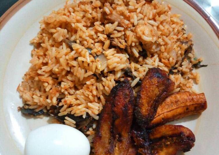 Dried catfish jollof rice with fried plantains and boiled egg