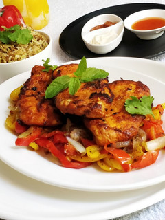 A picture of Pan Fried Chicken Breast on a bed of Pepper's and Onion.
