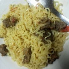 A picture of Cooked Noodles  with stew.