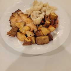 A picture of Roasted potatoes and white fish.