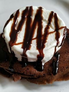 A picture of Non fermented chocolate Dosa with ice cream and chocolate sauce.