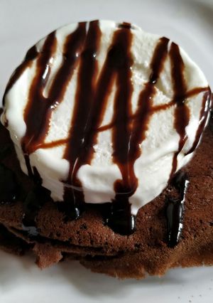A picture of Non fermented chocolate Dosa with ice cream and chocolate sauce.
