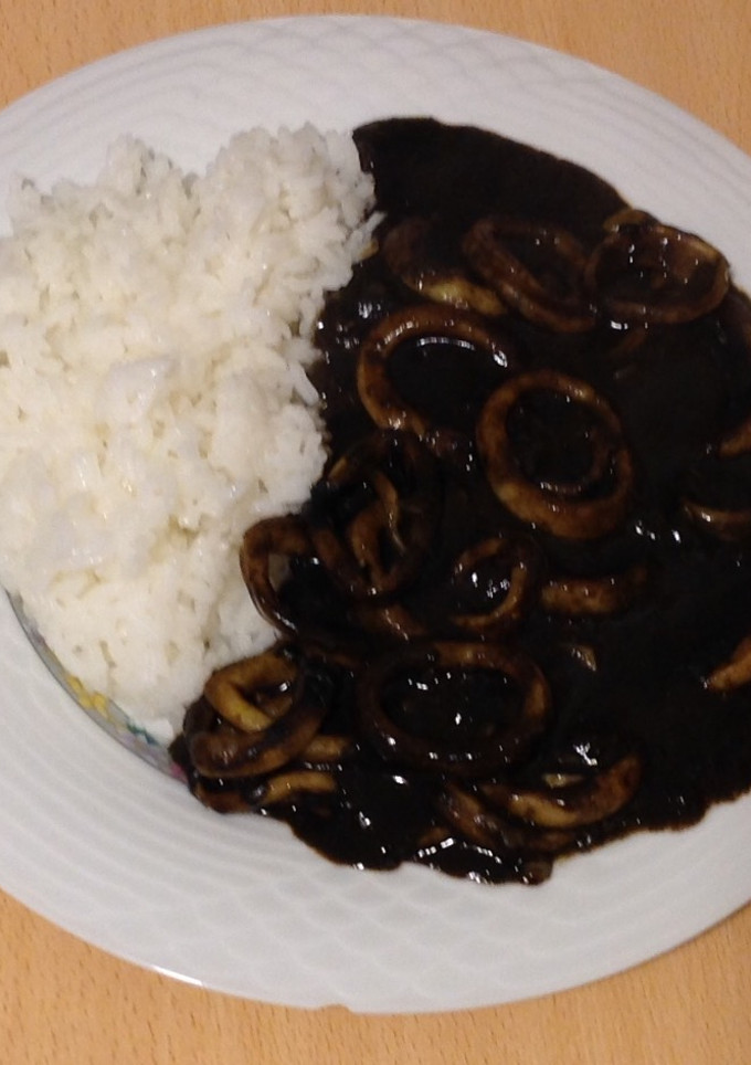 Una foto de Calamares en su tinta con arroz blanco